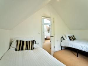 a white room with two beds and a mirror at School Path Ironbridge Home with Rear Terrace in Ironbridge