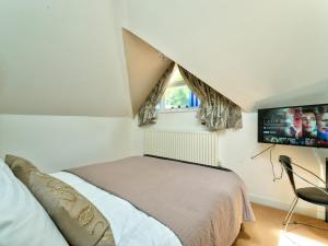 a bedroom with a bed and a flat screen tv at School Path Ironbridge Home with Rear Terrace in Ironbridge