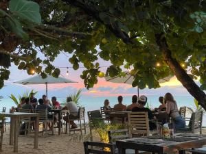 a group of people sitting at tables on the beach at Afreeka Beach Hotel in Las Terrenas