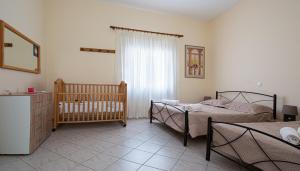 a bedroom with two twin beds and a crib at Palm Beach House in Sfinárion