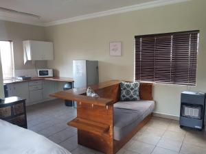 a living room with a couch and a kitchen at Private Apartments & Biz Stays Pretoria in Pretoria
