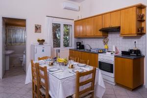 a kitchen with a table with a white table cloth on it at Palm Beach House in Sfinárion