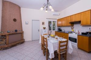 a kitchen with a table with a white table cloth at Palm Beach House in Sfinárion +35 photos