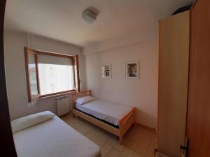 Rúm í herbergi á APPARTAMENTO ISIDE fronte spiaggia