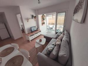 - un salon avec un canapé et une table dans l'établissement Apartamento a 300 mts de la playa, 25 minutos de Port Aventura y 50 de Barcelona, à Coma-ruga
