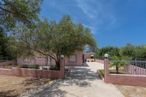 a house with a fence and a tree at Palm Beach House in Sfinárion