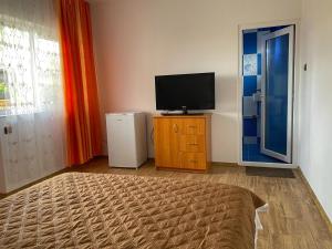 a room with a television and a dresser with a bed at Lovin's Rooms in Tuzla