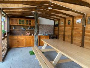 a large wooden kitchen with a wooden table in it at Lovin's Rooms in Tuzla
