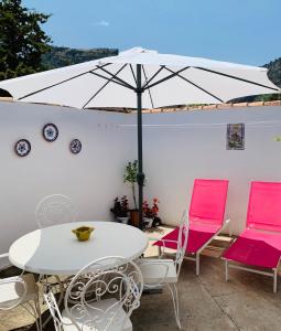 a table and chairs with an umbrella on a patio at La Casilla- La Almona Chica in El Chorro