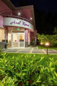 a pink and white building with a sign on it at Hotel Amel Rooms in Mediaş