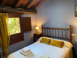 a bedroom with a bed with yellow pillows and a window at Can Bonada in El Serrat +97 photos
