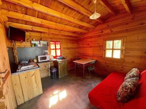 uma sala de estar com um sofá vermelho numa cabina de madeira em Domaine du vieux chêne em Bergerac