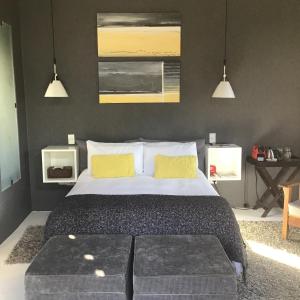 - une chambre avec un grand lit et 2 oreillers jaunes dans l'établissement Annis Nest, à Riebeek-Kasteel