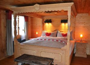 a bed room with a bed with a wooden headboard at B&B Rosaly in Chateau-d'Oex