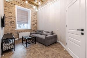 ein Wohnzimmer mit Sofa und Ziegelwand in der Unterkunft View on Rynok Square apartments in Lwiw
