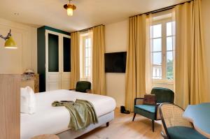 アルヴェルにあるChâteau Fage La Maison des Vignes - Groupe Teritoriaのベッド、テーブル、椅子が備わるホテルルームです。