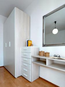 a white cabinet and a mirror in a room at Apartments TENA in Pula