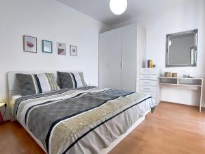 a white bedroom with a bed and a sink at Apartments TENA in Pula