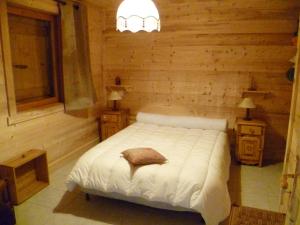 a bedroom with a white bed in a log cabin at Appartement de 3 chambres avec jardin amenage et wifi a Notre Dame de Bellecombe a 1 km des pistes in Notre-Dame-de-Bellecombe