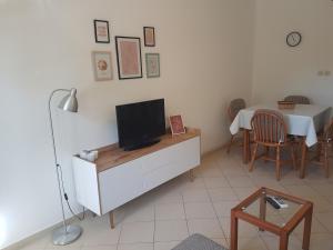 a living room with a tv on a cabinet with a table at Apartments TENA in Pula