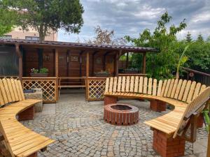 a patio with two wooden benches and a fire pit at Lovin's Rooms in Tuzla