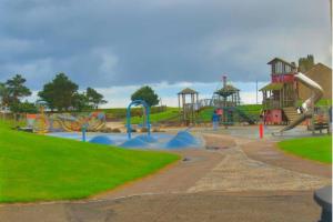 un parque con parque infantil con toboganes y atracciones en ☆ New Superhost Listing- Broughty Ferry Studio ☆ en Broughty Ferry