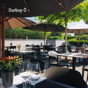 a restaurant with tables and chairs and umbrellas at Hotel Durbuy Ô in Durbuy