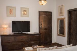 a living room with a television on a wooden dresser at Pouso da Torre in Tiradentes