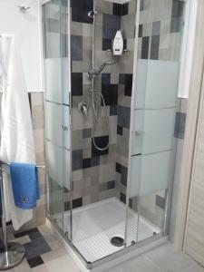 a shower with a glass door in a bathroom at DA ISINOE in Mascali