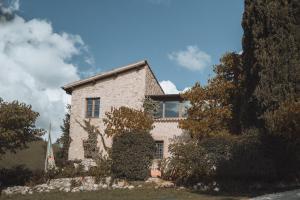 una gran casa de piedra con árboles delante de ella en Albergo Le Casaline, en Campello sul Clitunno