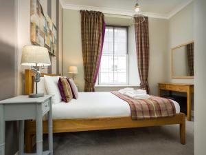 Schlafzimmer mit einem Bett und einem Fenster in der Unterkunft Old Town Suites - Nicolson in Edinburgh