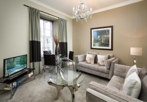 a living room with a couch and a tv at Old Town Suites - Nicolson in Edinburgh
