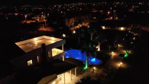 a house with a swimming pool at night with lights at ALASHATO Alacati in Alaçatı