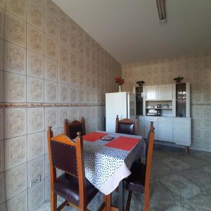 a kitchen with a table and chairs and a refrigerator at Casa Quintanilha in Campos do Jordão