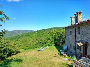 una casa con un patio con sillas y una montaña en La fonte di Gaiche, en Collebaldo