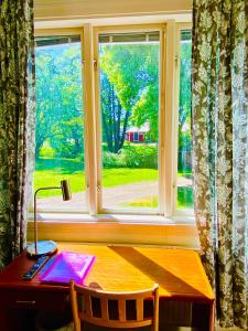 a window with a desk and a table with a lamp at Solakoop B&B in Karlstad