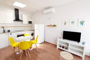 Precioso apartamento ecológico y sostenible في فيرا: مطبخ مع طاولة وكراسي صفراء في مطبخ