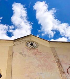 a clock on the side of a building with a blue sky at A REALDO - Casa Il Nido Delle Aquile in Triora