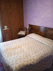 a bedroom with a large bed with a wooden headboard at A REALDO - Casa Il Nido Delle Aquile in Triora