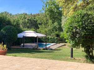 uma piscina com um guarda-sol ao lado de uma piscina em Casa Rural “La Julianita” em Castaño de Robledo