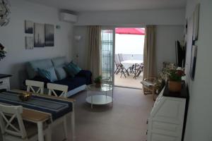 salon z niebieską kanapą i stołem w obiekcie Bajamar 13, vistas desde la azotea, wifi gratis w mieście Nerja