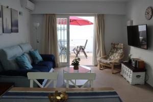 een woonkamer met een bank en een tafel bij Bajamar 13, vistas desde la azotea, wifi gratis in Nerja
