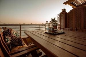 a wooden table on a balcony with a view of the water at Nile Transport Hotel in Cairo