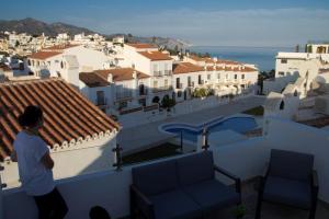 osoba stojąca na dachu patrząca na miasto w obiekcie Bajamar 13, vistas desde la azotea, wifi gratis w mieście Nerja