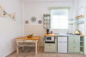 a small kitchen with a table and a microwave at STUDIO ASTERO in Pefki Rhodes