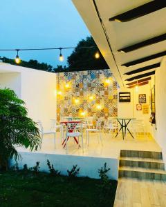 a patio with a table and chairs and a wall at Hotel Casa San Juan in Managua