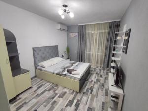1 dormitorio con 1 cama y TV en Къща за гости Атмосфера, en Tsarevo