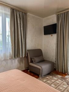 a bedroom with a bed and a chair and a television at Morskyi 487 in Zatoka