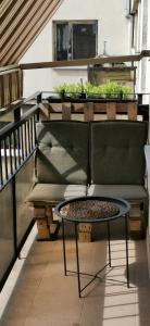 a patio with a couch and a table on a balcony at Pulawska 53 in Warsaw