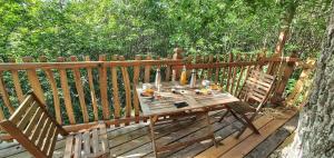 a wooden table and chairs on a wooden deck at Ô Bois Dormant in Lempzours